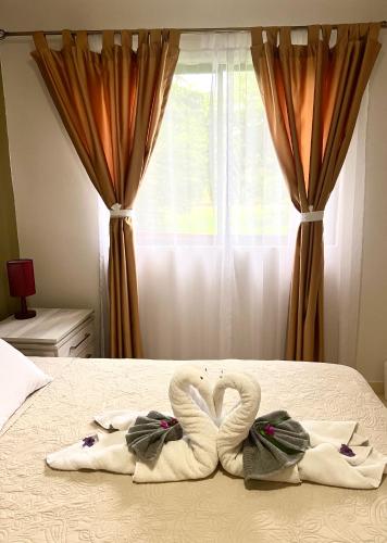 two towels shaped like swans sitting on a bed at Sunny Tropical Condo And Rooftop Terrace in Coco