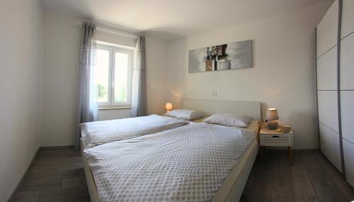 a bedroom with a large bed and a window at Apartments Goltes in Lovrečica