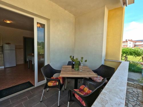 a table and chairs on a patio with a kitchen at Apartments Goltes in Lovrečica