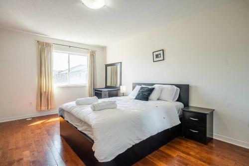 - une chambre avec un grand lit et une fenêtre dans l'établissement Beautiful Townhouse In Toronto, à Toronto