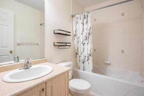 La salle de bains est pourvue d'un lavabo, de toilettes et d'une baignoire. dans l'établissement Beautiful Townhouse In Toronto, à Toronto