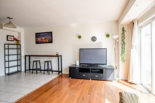 a living room with a flat screen tv and a table at Beautiful Townhouse In Toronto in Toronto