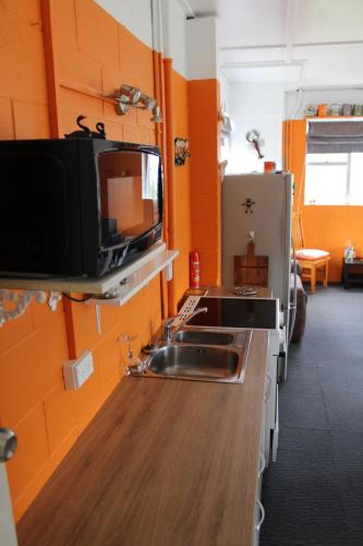 cocina con fregadero y TV en la pared en Corotime ~ Boat Parking ~ Pet Friendly, en Coromandel