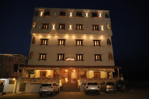 a large white building with cars parked in front of it at Teerth Palace Pushkar in Pushkar