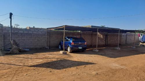 Niebieski van zaparkowany pod namiotem na polu piaskowym w obiekcie Victorious Guest House w mieście Tongwe