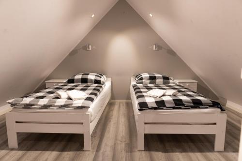 two beds in a room with a attic at Domek u Mai in Krośnica