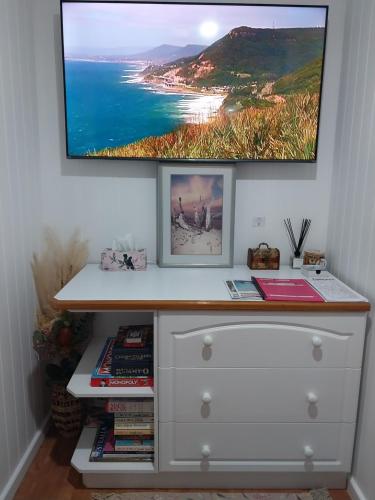 a white dresser with a television on top of it at The Treasure Box in Esperance