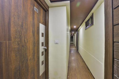 un pasillo con una puerta que conduce a una habitación con suelo de madera en OYO Hotel Sree Balaji Residency, en Bodakdev