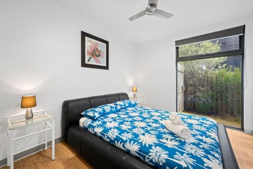 洛恩的住宿－Zahra Lodge，一间卧室配有一张带蓝色和白色床单的床和窗户。