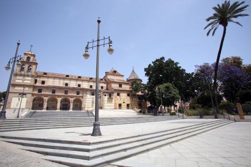 a building with a palm tree and a street light at Málaga Lodge Guesthouse in Málaga