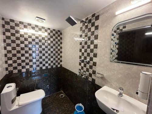 a bathroom with a white toilet and a sink at Hotel Shannti Inn in Varanasi