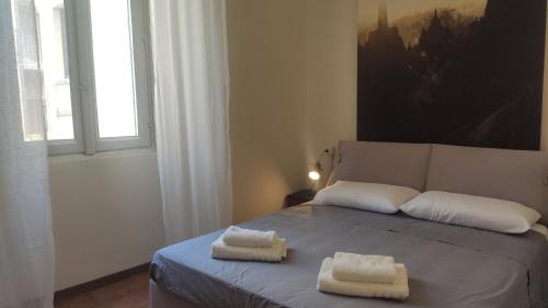 a bedroom with a bed with two towels on it at Casa vacanze in centro in Lecco