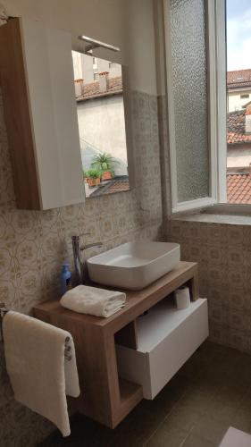 y baño con lavabo y espejo. en Casa vacanze in centro en Lecco
