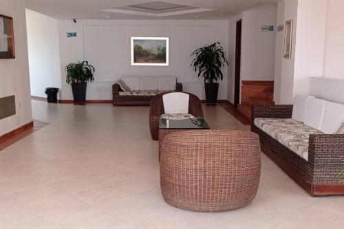 a living room with wicker chairs and a couch at Apartamento con maravillosa vista al río Fonce in San Gil