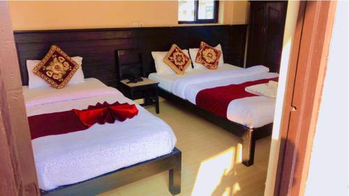 博卡拉的住宿－Hotel Sarathi，一间卧室配有两张红色和白色床单