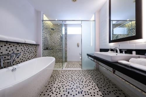 uma casa de banho com uma banheira, um lavatório e um chuveiro em Lone Pine, Penang, a Tribute Portfolio Resort em Batu Ferringhi