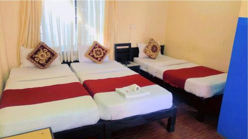 博卡拉的住宿－Hotel Sarathi，酒店客房设有两张床,并备有托盘。