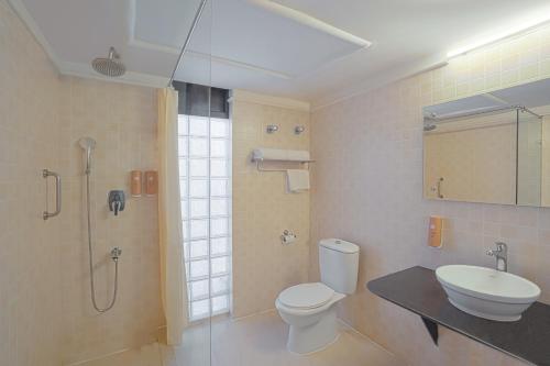 y baño con aseo, lavabo y ducha. en Country Inn Tarika Goa Varca Beach, en Varca
