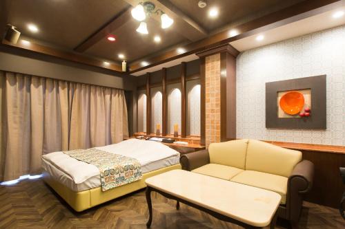 um quarto com uma cama, um sofá e uma mesa em ホテルシエル沼津店 -大人専用- em Numazu