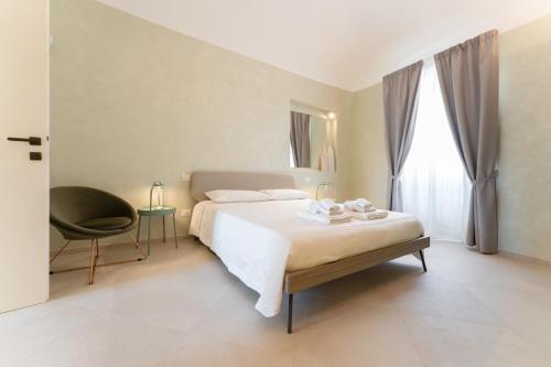 a bedroom with a bed and a chair and a window at 42° parallelo in Termoli