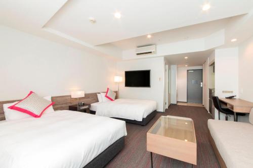 a hotel room with two beds and a table at Tokyu Stay Gotanda in Tokyo