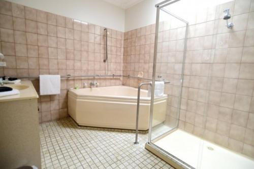 a bathroom with a bath tub and a shower at Benalla Apartments in Benalla