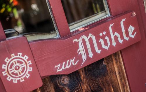 a red door with the words zur malik on it at Zur Mühle Wohlfühloase in Trodena