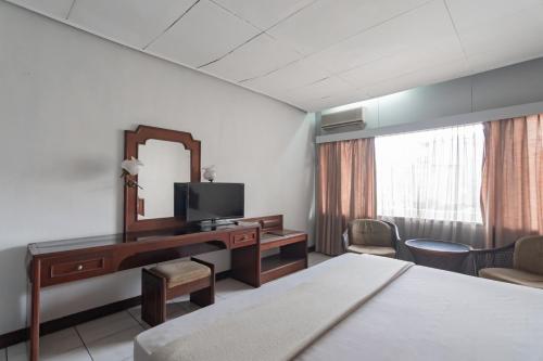 a hotel room with a desk and a mirror at Istana Hotel Bandung Mitra RedDoorz in Bandung