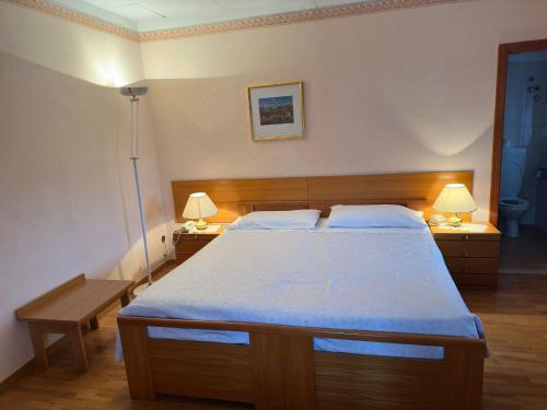 una camera con un grande letto con due lampade di VILLA NUOVA a Romeno