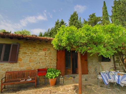 a house with a table and a bench in front of it at Cottage La Stefania near Anghiari in beautiful setting in Misciano