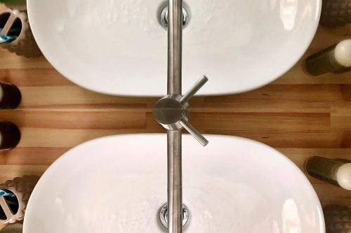 a white toilet bowl with a clock on the wall at Riverstone Villas with private pools in Levktron