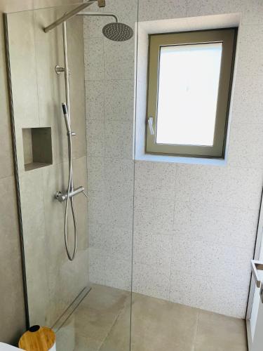 a bathroom with a shower with a glass door at Riverstone Villas with private pools in Levktron