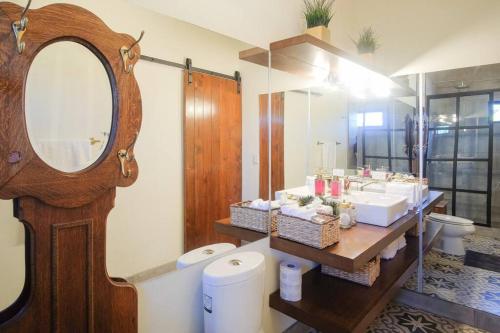 een badkamer met een spiegel, een wastafel en een toilet bij Casa Capilla @ Casa Frida Valle de Gpe in San Marcos