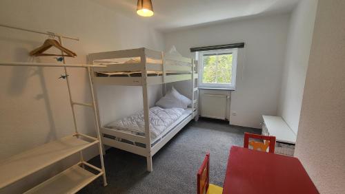 Pokój z 2 łóżkami piętrowymi i oknem w obiekcie Ferienhaus Heart's Home Hahnenklee Harz w mieście Hahnenklee-Bockswiese