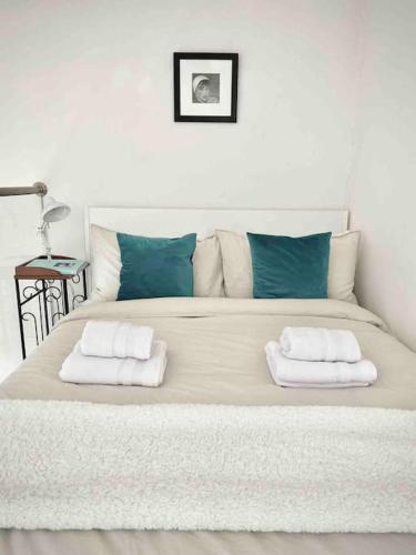 ein großes Bett mit zwei Kissen darüber in der Unterkunft Shoreditch Loft in London