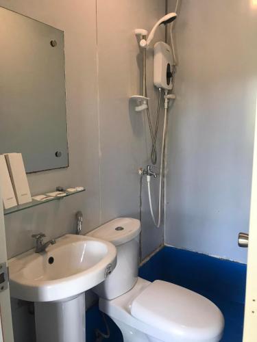 a small bathroom with a toilet and a sink at Happy Daze Resort Hotel in Mabini