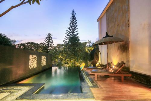 a swimming pool in a backyard with a house at KajaNe Mua at Ubud Bali in Ubud