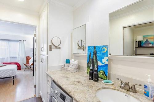 een witte badkamer met een wastafel en een spiegel bij Condo in Most sought after neighborhoods in Oakland