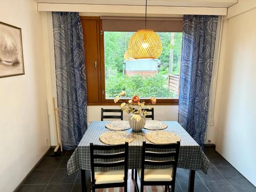 a dining room with a table and chairs and a window at Spacious and modern apartment in Mikkeli