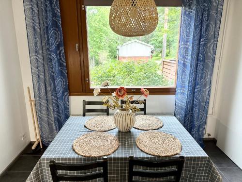 a dining room table with two chairs and a vase with flowers at Spacious and modern apartment in Mikkeli