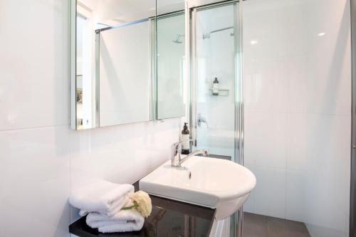 Un baño blanco con lavabo y ducha. en Mariners Retreat Jervis Bay, en Vincentia