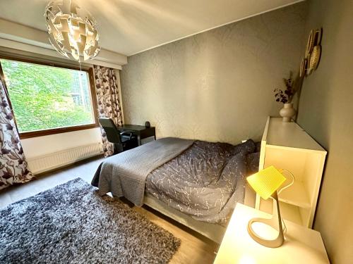 1 dormitorio con cama y ventana en Spacious and modern apartment en Mikkeli