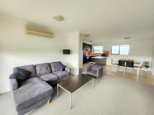 a living room with a couch and a table at Oceanic on Thompson Apartments in Cowes