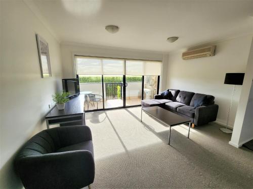 a living room with two couches and a television at Oceanic on Thompson Apartments in Cowes