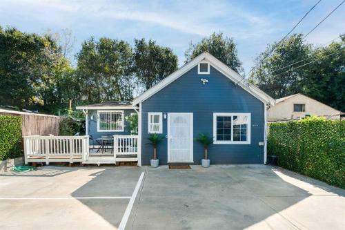 a blue house with a porch and a driveway at Modern Cottage near many conveniences in Oakland
