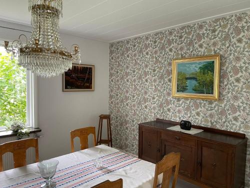 a dining room with a table and a chandelier at Villa Walterängen in Tibro