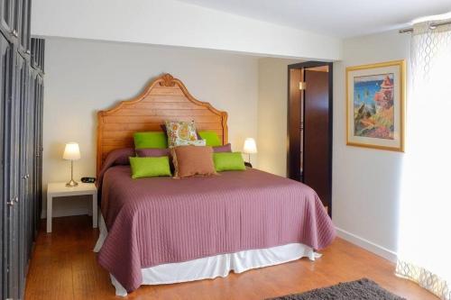 a bedroom with a large bed with green and brown pillows at Hip Casa Beatles in downtown Gated Parking in Ensenada