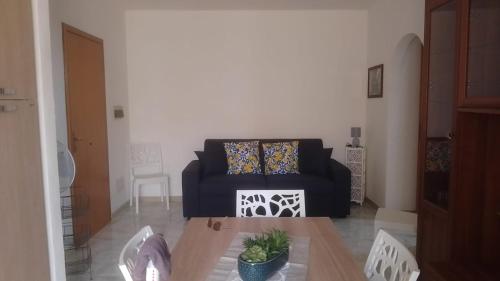 - un salon avec un canapé noir et une table dans l'établissement Casetta Cavour, à Pantelleria