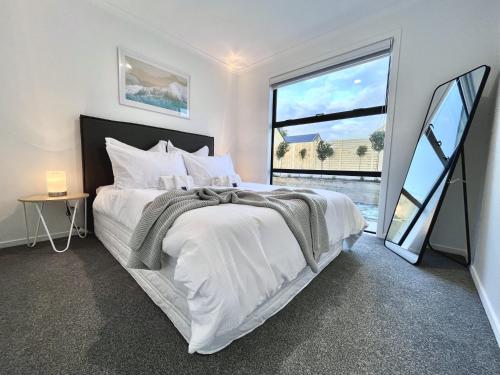 sypialnia z białym łóżkiem i dużym oknem w obiekcie Brand New & Ready for You! By KOSH BNB w mieście Hamilton