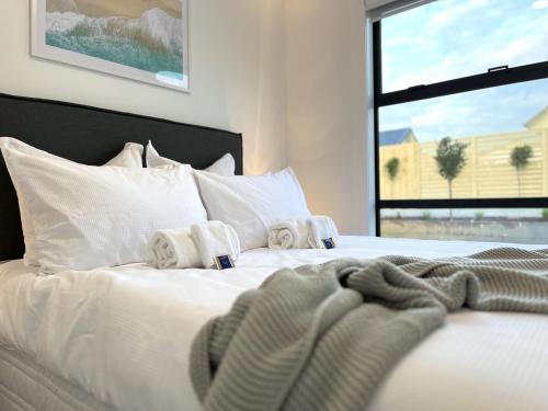 białe łóżko z ręcznikami i oknem w obiekcie Brand New & Ready for You! By KOSH BNB w mieście Hamilton